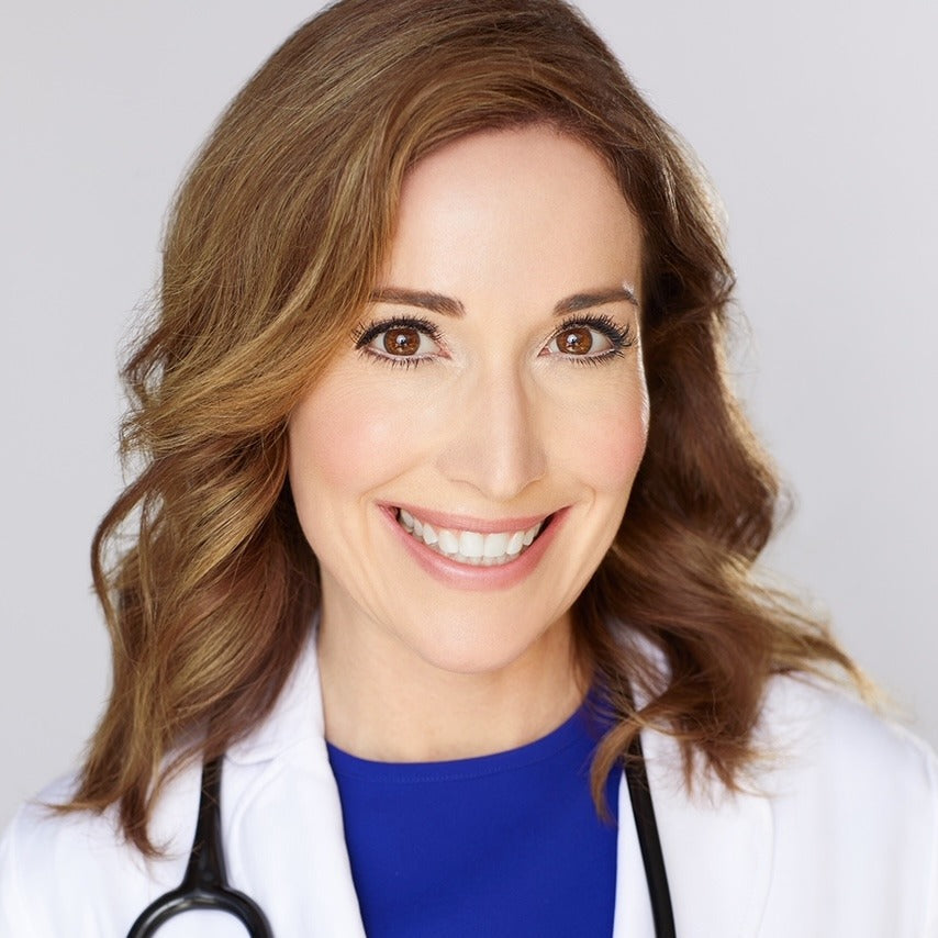 Smiling female doctor with brown hair wearing a white coat and stethoscope