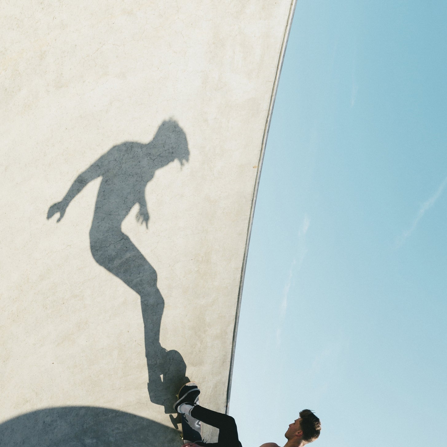 Active skateboarder's shadow on ramp.