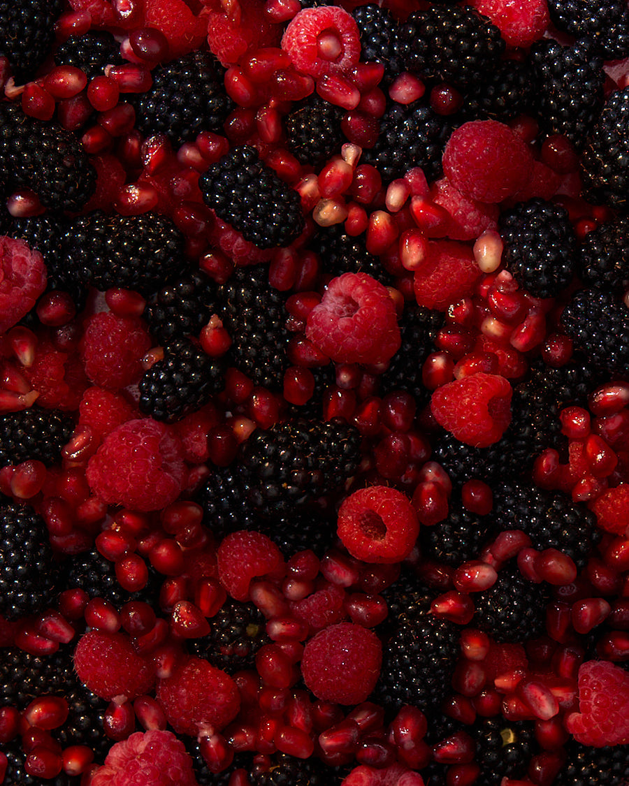 Close-up of Berry Pomegranate Bulk Jar showcasing raspberries, blackberries, and pomegranate seeds on a dark background