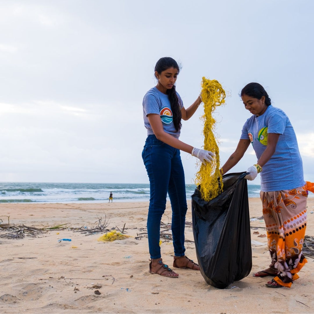 Two people cleaning a beach.