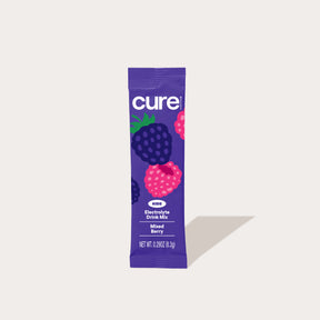 Purple 'cure' sample stick packet with berry illustrations, labeled 'Electrolyte Drink Mix' and 'Mixed Berry'.