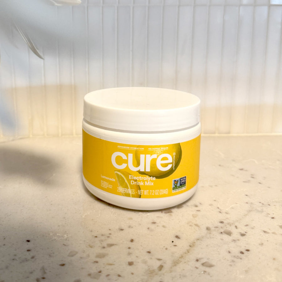 Front view of Lemonade Bulk Jar showing yellow Cure label with Electrolyte Drink Mix text on a white countertop