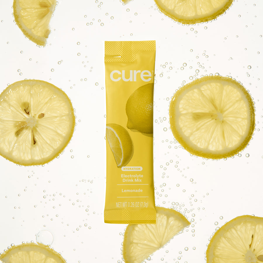 Front view of Lemonade electrolyte stick showing Cure logo and lemon graphics with sliced lemons in fizzy water