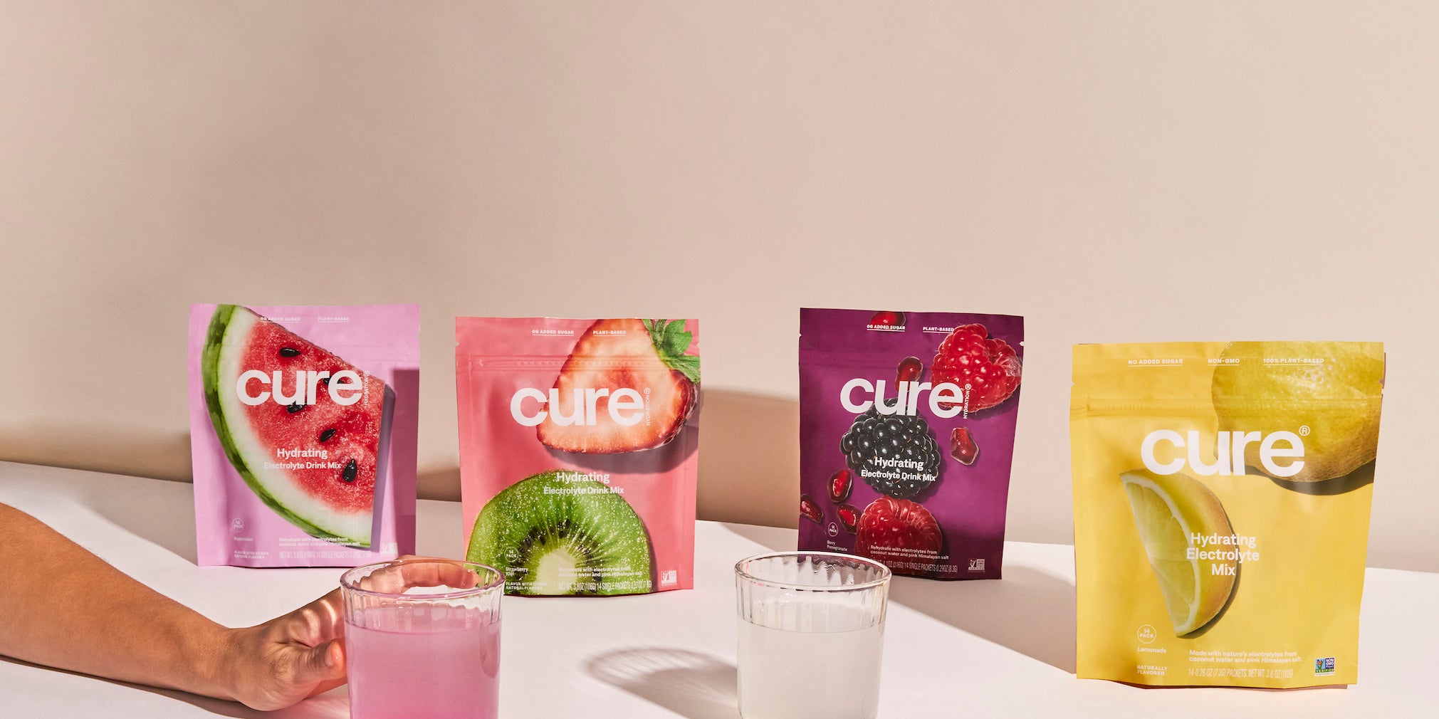 'Cure' mix packets in watermelon, kiwi, berry, lemon flavors on a table.