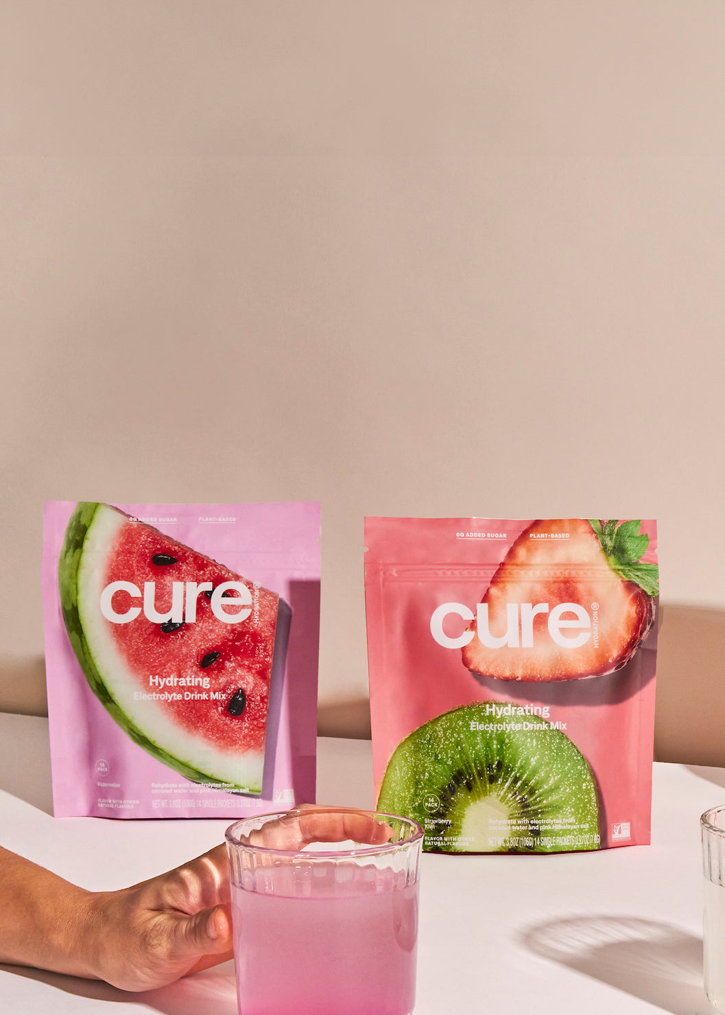'Cure' mix packets in watermelon, kiwi, berry, lemon flavors on a table.
