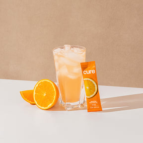 Orange-flavored drink with mix packet and orange slices.